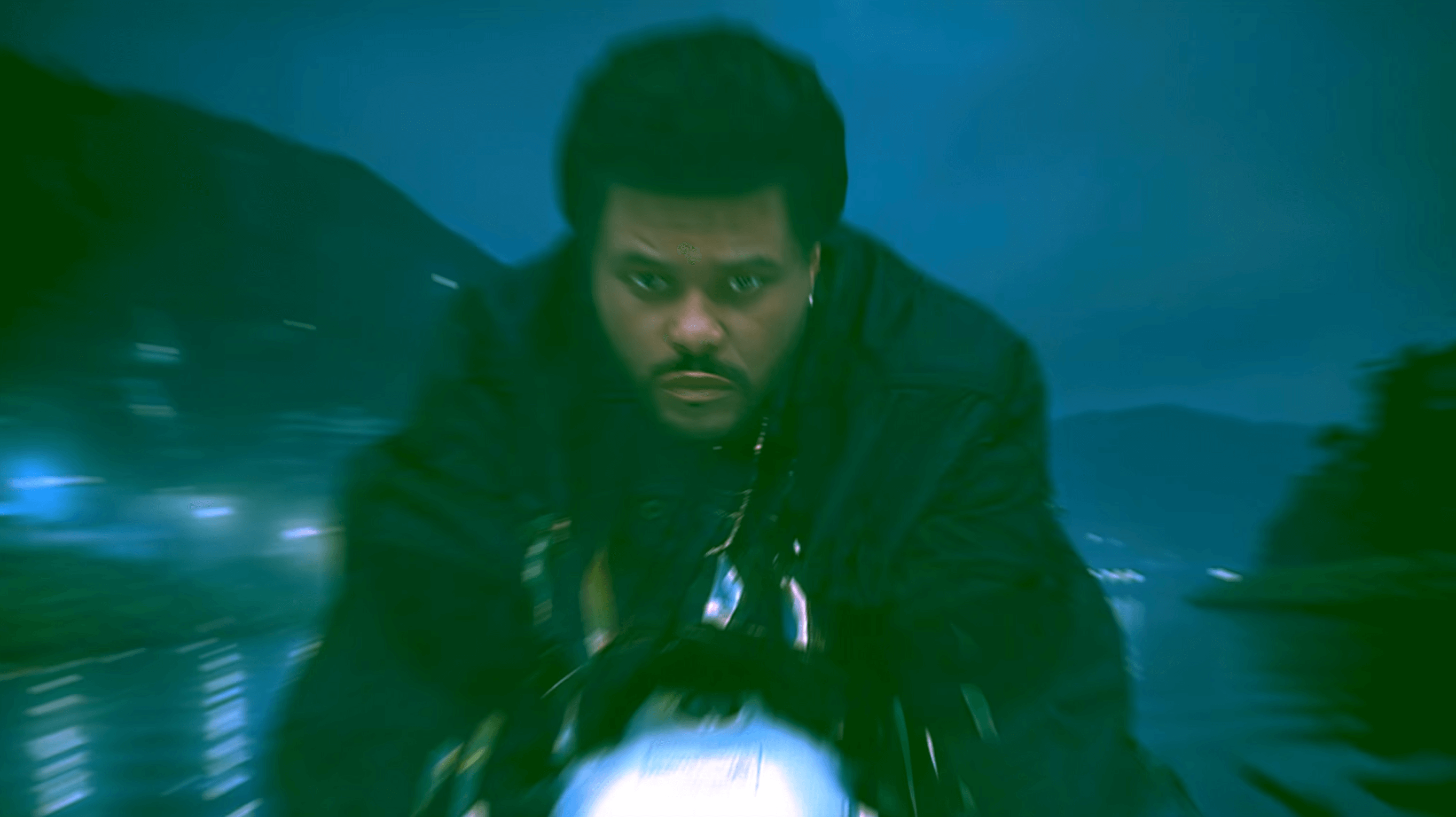 Popstar Abel Tesfaye AKA The Weeknd riding a motorcycle towards the camera.